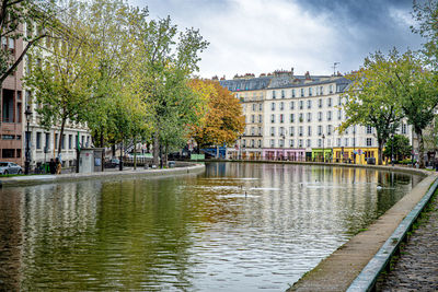 Canal amidst buildings against sky