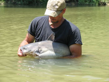 Full length of man holding fish in river