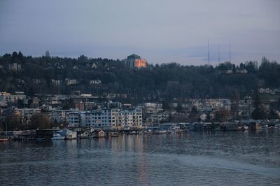 Scenic view of river by town against sky