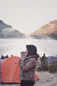 Rear view of woman in lake against sky