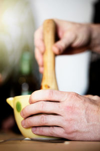 Close-up of man holding ice cream on table