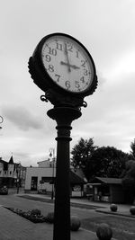 Low angle view of clock against sky