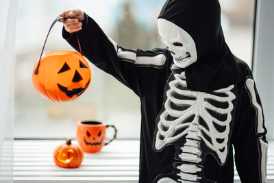 Midsection of woman holding jack o lantern