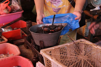 Midsection of man preparing food for sale at market stall