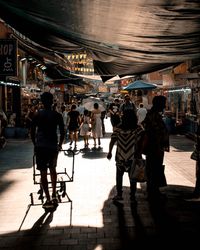 Rear view of people walking on street in city