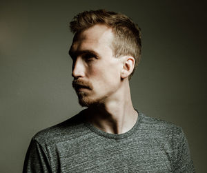 Thoughtful young man against gray background