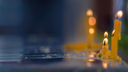 Close-up of lit candles in temple