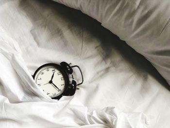 Close-up of alarm clock on bed