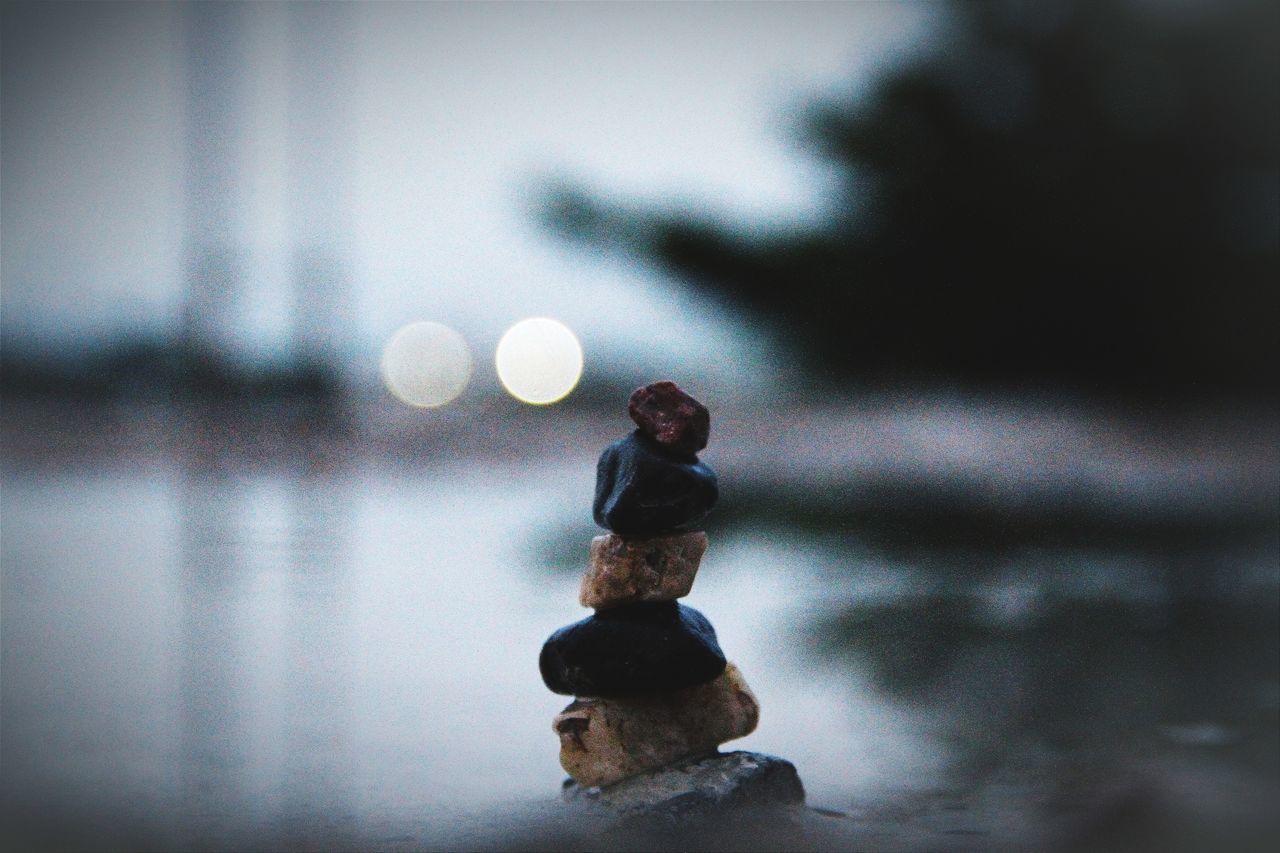 CLOSE-UP OF STONE STACK AGAINST RIPPLED WATER