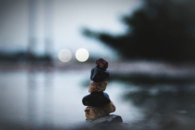Close-up of stone stack against water