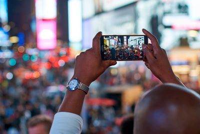 Cropped hand of woman using mobile phone