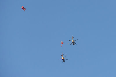 Low angle view of airshow against clear blue sky