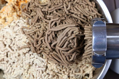 High angle view of grinder grinding fresh meat over container