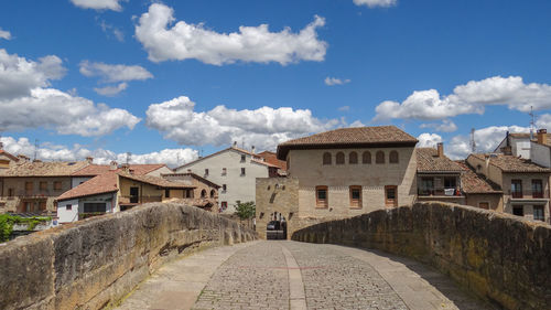 Street amidst buildings in town against sky