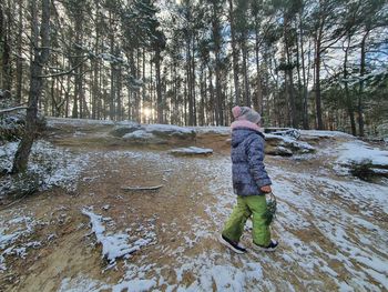 Rear view of woman standing on snow covered land