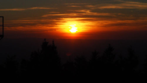 Scenic view of silhouette trees against romantic sky at sunset