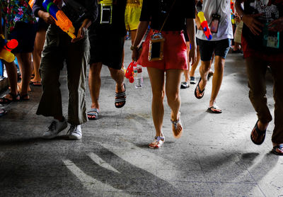 Low section of people walking on street in city