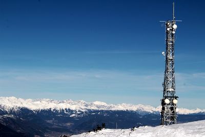 Communications tower against sky during winter