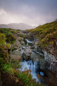 Scenic view of river amidst mountains against sky