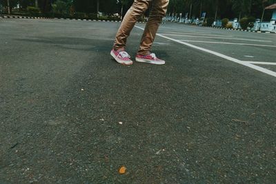 Low section of woman standing on road