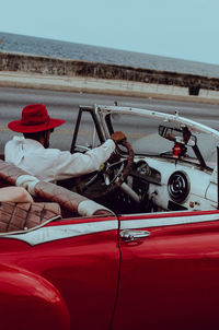 Man driving vintage car against sea