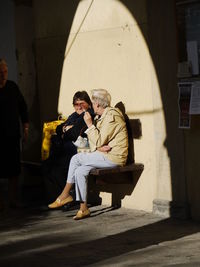 Full length of couple holding hands while sitting on floor