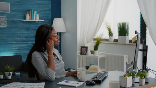 Woman sitting on table at home