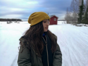 Woman wearing hat standing in snow