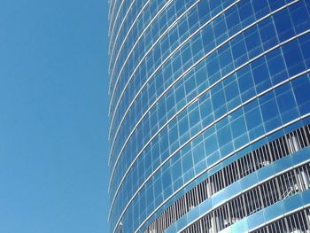 Low angle view of skyscraper against clear blue sky