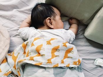 High angle view of baby girl sleeping on bed at home