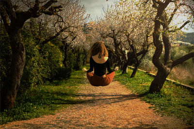 Rear view of woman in lotus position levitating