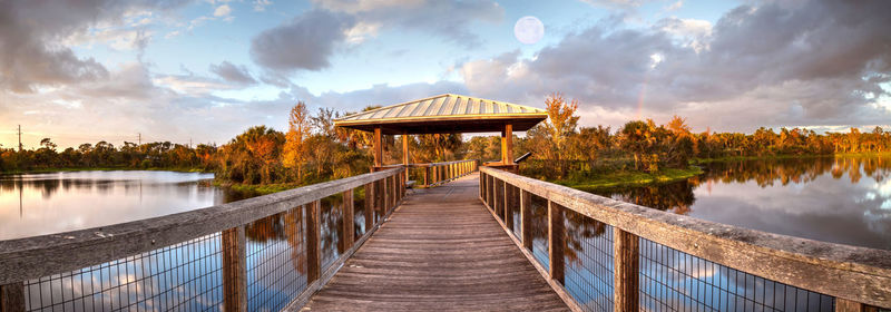  sunset over gazebo on a wooden secluded, tranquil boardwalk along a marsh pond in freedom park