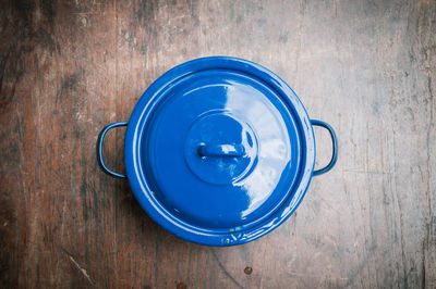 Directly above shot of blue cooking pot on wooden table