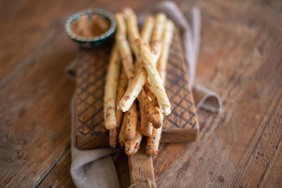 Grissini - italian bread sticks with dried herbs on a wooden background. close up.