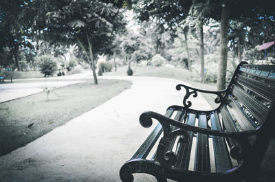 Empty bench in park during winter