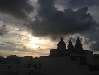 High section of buildings against cloudy sky at sunset