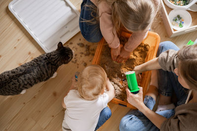 High angle view of people sitting on wooden floor