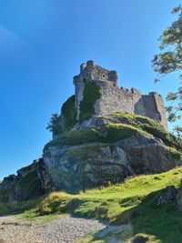 Low angle view of old ruin building against blue sky
