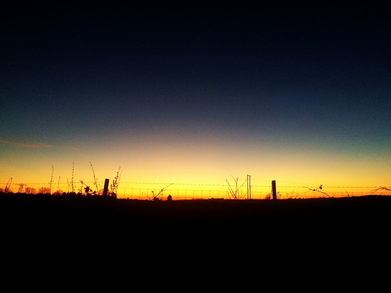 SILHOUETTE LANDSCAPE AGAINST CLEAR SKY DURING SUNSET