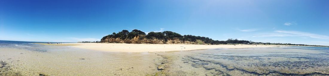 Scenic view of beach against blue sky