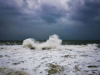 Water splashing in sea against sky
