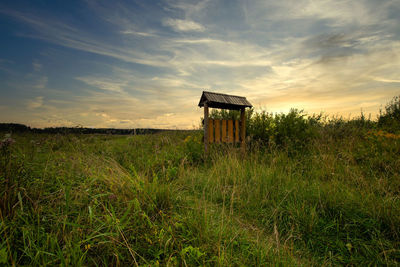 Built structure on field against sky during sunset