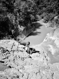 High angle view of man sitting on rock