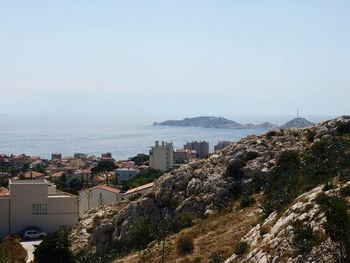 High angle view of cityscape by sea against sky