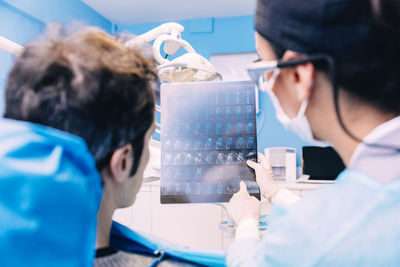 Female dentist showing x-ray to patient at clinic