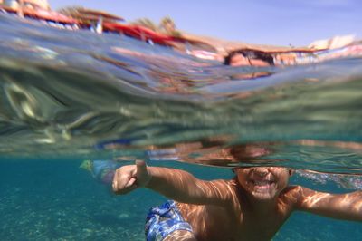 Shirtless boy swimming in sea