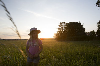 Man standing on field against sky during sunset