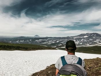 Rear view of woman looking at snowcapped mountain against sky