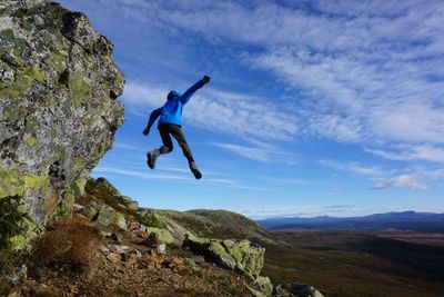 Low angle view of person jumping off a cliff