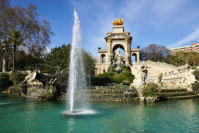 Fountain in pond at parc de la ciutadella against sky